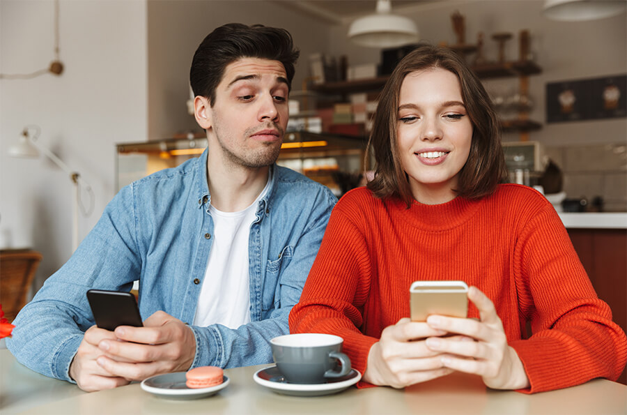 Young couple applying for life insurance on their mobile phones